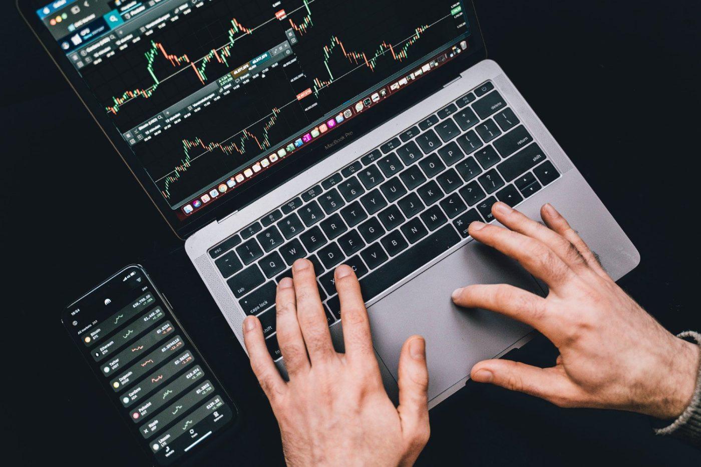 Hands on a laptop with live performance charts